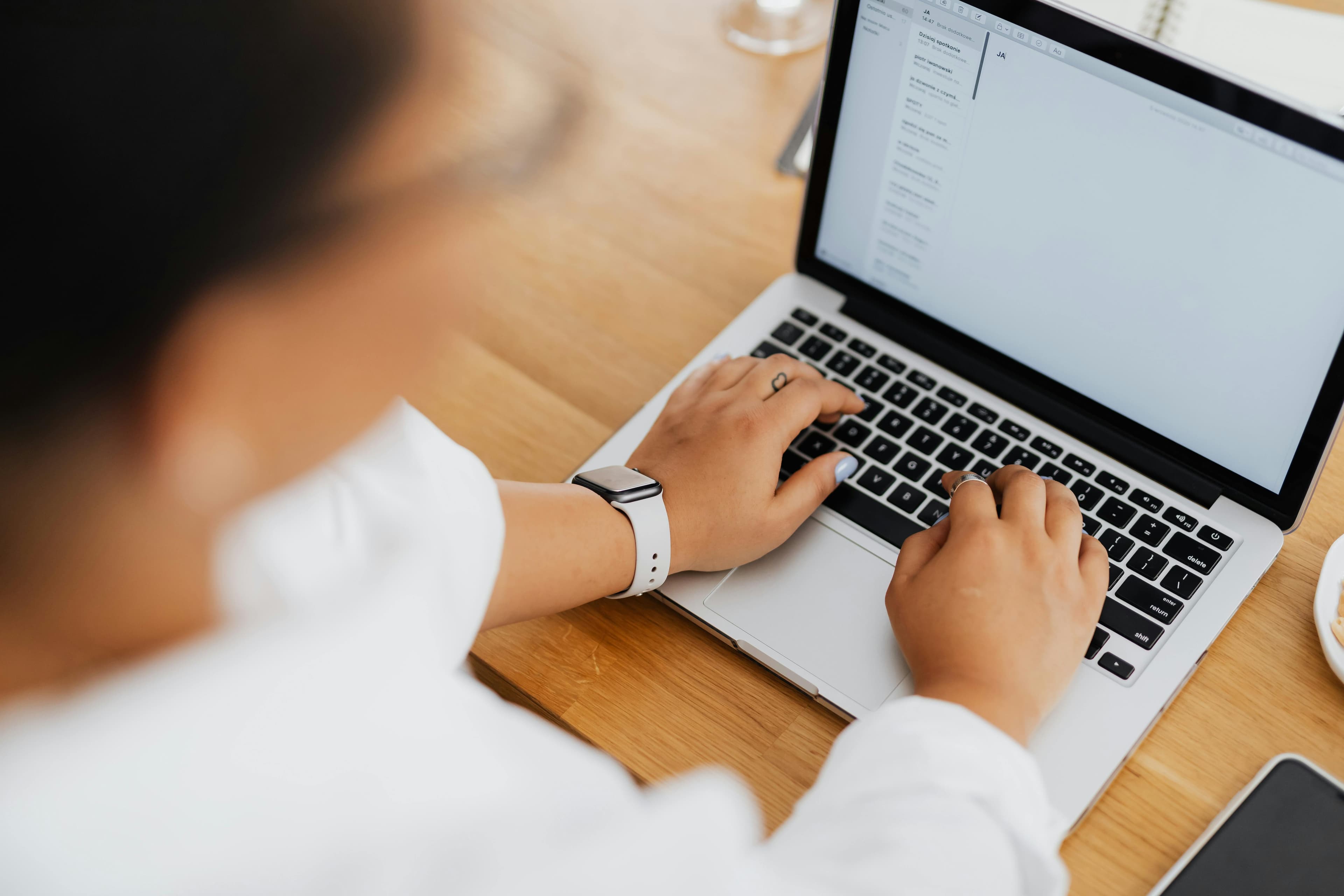 Person sits at a laptop writing an email.